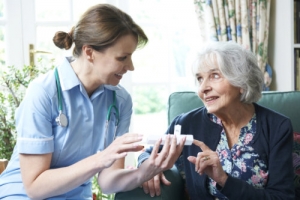nurse advising senior woman on taking medication