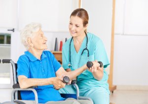 senior woman lifting dumbbells in physiotherapy